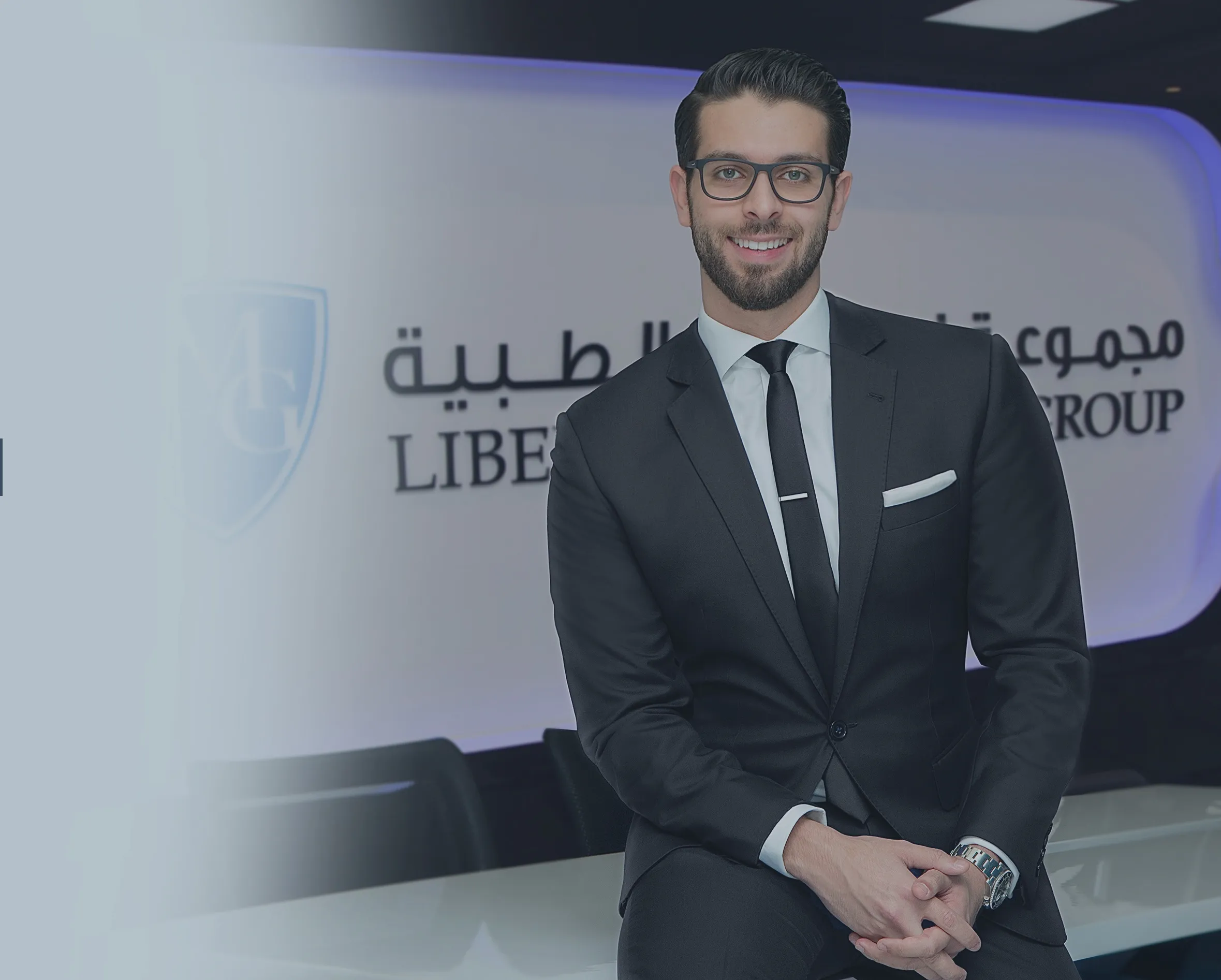 Dr. Mohammed Naji seated in a dark suit at Liberty Medical Group